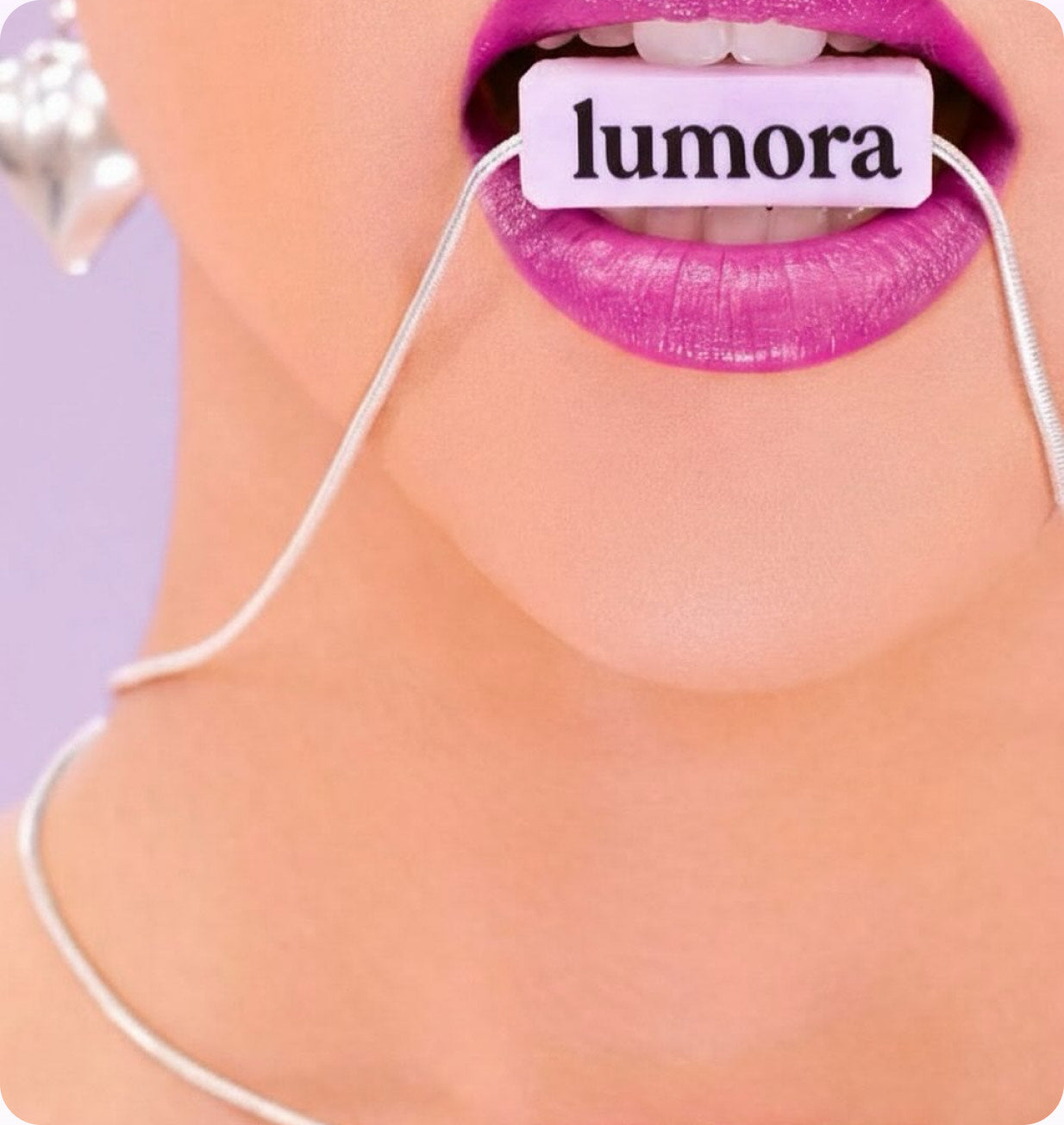 Close-up of a woman's lips holding a Lumora branded floss tag